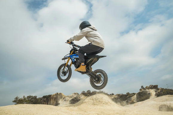 Zonveer DX1 electric dirt bike jumping over rolling sand dunes