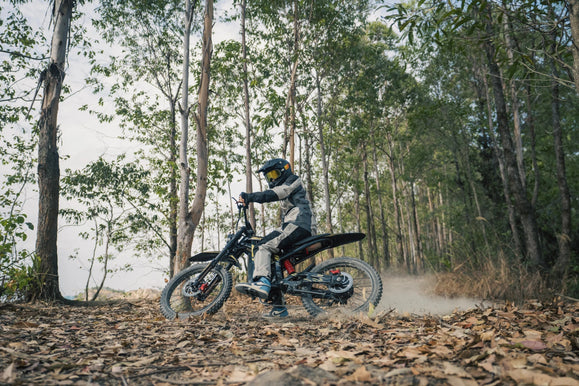 Zonveer ZX3 electric dirt bike on a muddy forest trail with tool kit planning